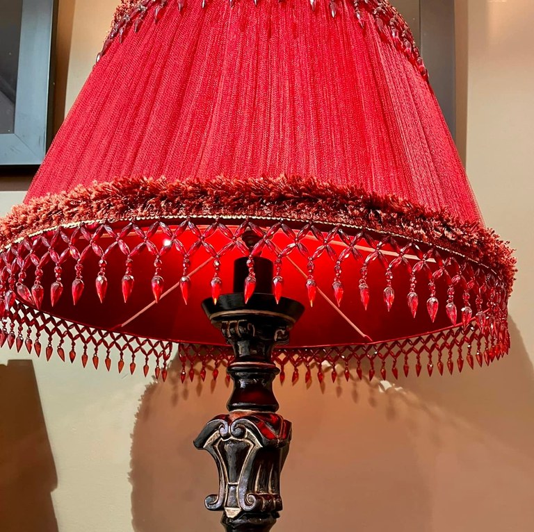 Large lamp with carved black lacquered wood base and deep wine red shade with stone fringing: R3,500