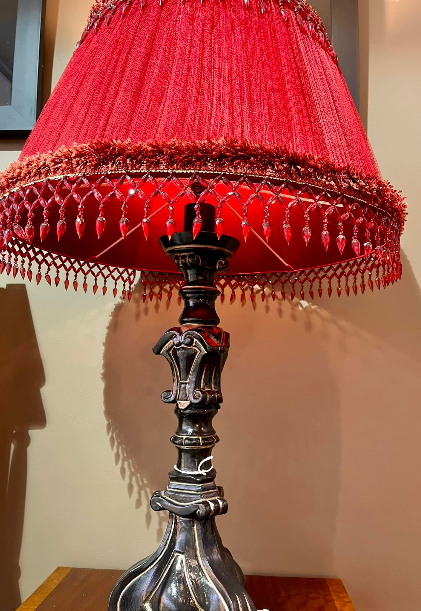 Large lamp with carved black lacquered wood base and deep wine red shade with stone fringing: R3,500