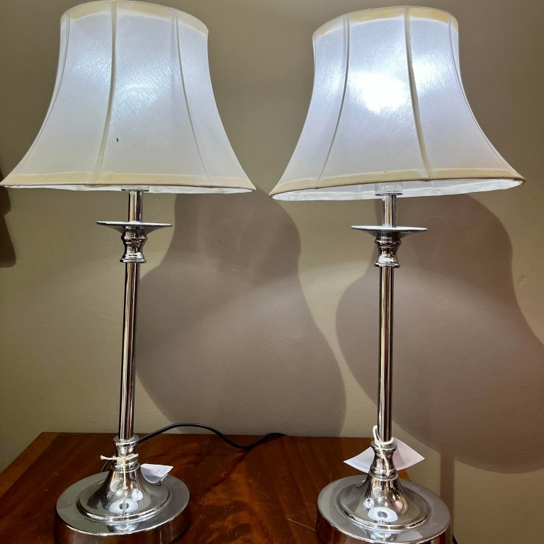 Pair of lamps with silver steel pillar bases and white silk shades: R1,600