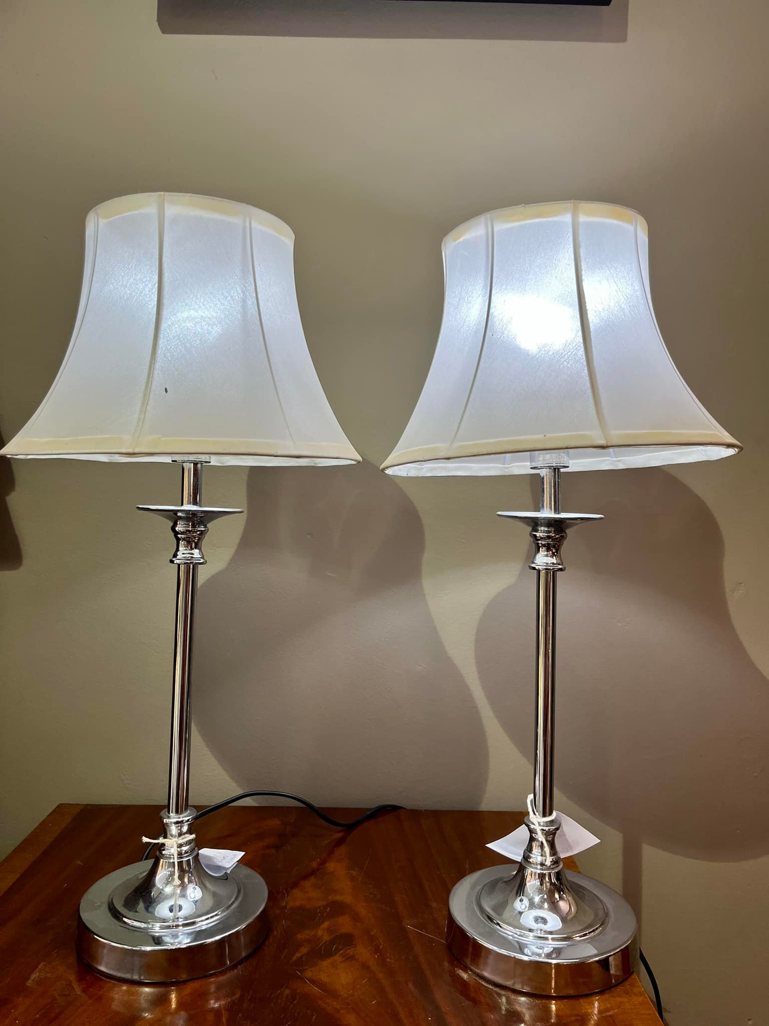 Pair of lamps with silver steel pillar bases and white silk shades: R1,600