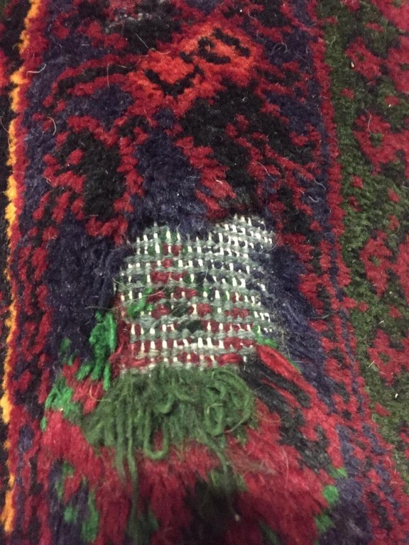 A warn carpet pile in the process of repair