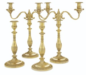 A PAIR OF GEORGE III SILVER-GILT TWO-LIGHT CANDELABRA AND A PAIR OF MATCHING CANDLESTICKS