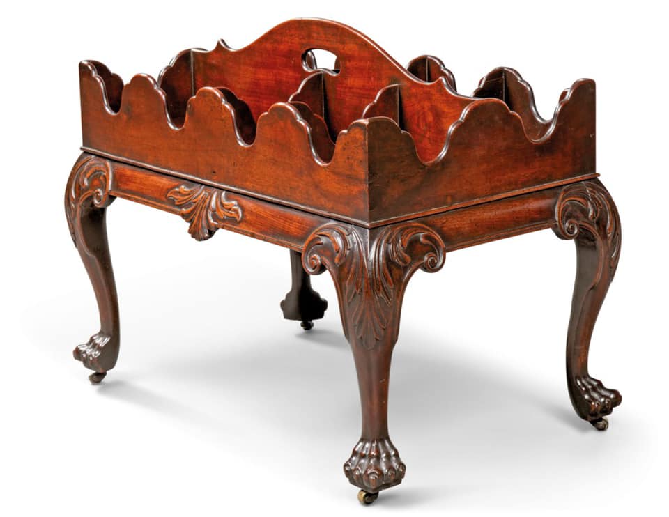 AN IRISH GEORGE II MAHOGANY DECANTER STAND, CIRCA 1750, With carrying-handle above six divided compartments and waved gallery, on acanthus-headed cabriole legs with paw feet and castors, inscribed TC152 to underside, 22 in. (56 cm.) high; 26 in. (66 cm.) wide; 16 ½ in. (42 cm.) deep. Estimate: 6,000 - 10,000 GBP. SOLD for 8,750 GBP