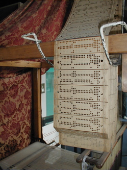 Punched cards in use in a Jacquard loom.